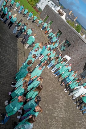 Menschenkette bildet grüne Schleife