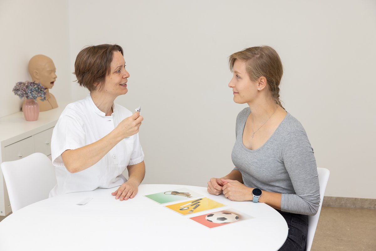 Logopädin am Tisch mit Patientin