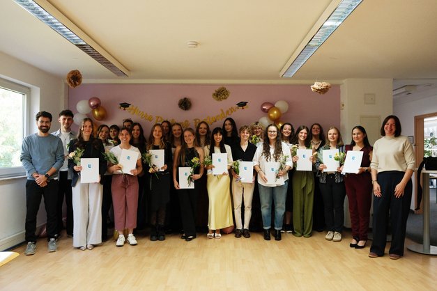 22 Auszubildende bestehen Ergotherapie-Examen Absolventinnen und Absolventen der Ergotherapie Schule Mainz zeigen Ihre Examen in die Kamera.