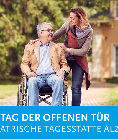 Frau geht mit einem Senioren im Rollstuhl spazieren.