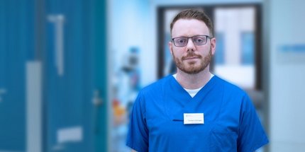 Stationsleiter Torsten Hellinger steht im Flur der Neurologie 