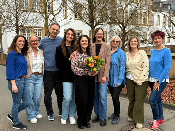 Despoina Braun bekommt im Kreis des Teams der Pflegeschule einen Blumenstrauß