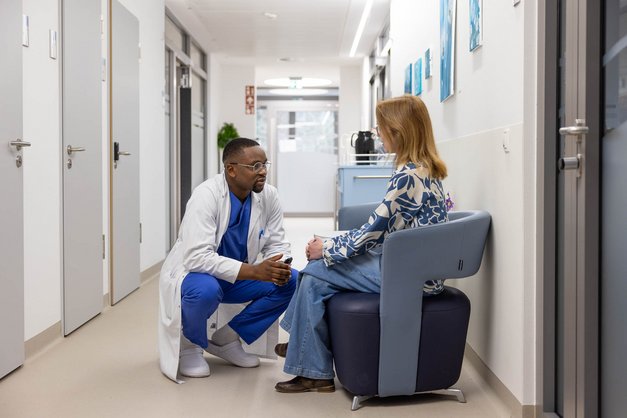 Ein Neurologe einer Einrichtung des Landeskrankenhauses tauscht sich mit einer Patientin aus.